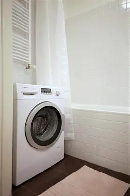 a washing machine in a bathroom with a tub at City Castle Aparthotel in Prague