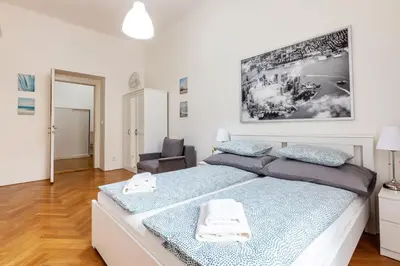 a bedroom with a large bed and a chair at City Castle Aparthotel in Prague