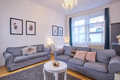 a living room with two couches and a table at Charles Bridge Premium Residence in Prague