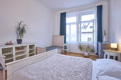 a bedroom with a white bed and a window at Charles Bridge Premium Residence in Prague