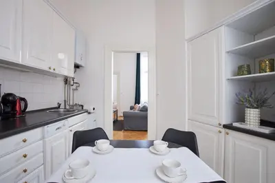 a white kitchen with a table and chairs at Charles Bridge Premium Residence in Prague