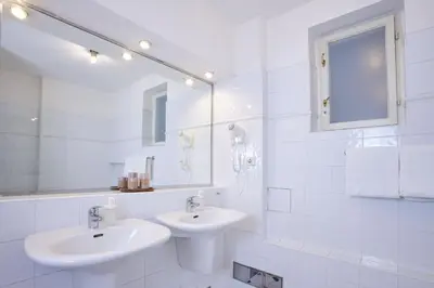 a white bathroom with two sinks and a mirror at Charles Bridge Premium Residence in Prague