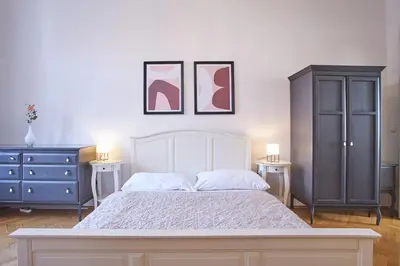 a bedroom with a bed and a dresser and two lamps at Charles Bridge Premium Residence in Prague