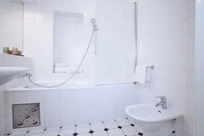 a white bathroom with a sink and a shower at Charles Bridge Premium Residence in Prague