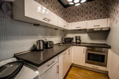 a small kitchen with white cabinets and a sink at Stylish Apartments close to Eden Garden in Prague