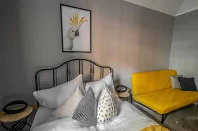a bedroom with a bed and a yellow chair at Stylish Apartments close to Eden Garden in Prague