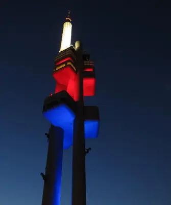 a red and blue traffic light with a building in the background at Cosy Apartment Under the Tower in Prague
