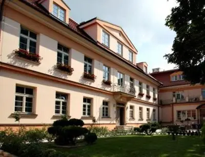 a large building with windows and plants in a yard at Castle Residence Praha in Prague