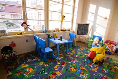 a childs play room with a table and toys on a rug at Castle Residence Praha in Prague