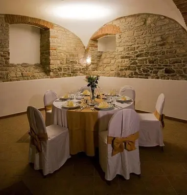 a dining room with a table and chairs and a stone wall at Castle Residence Praha in Prague