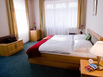 a bedroom with a large bed and a window at Castle Residence Praha in Prague