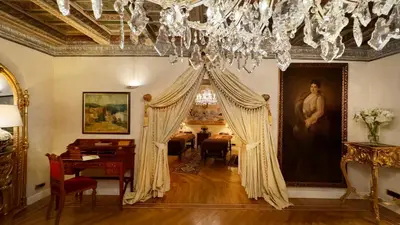 a living room with a chandelier and a dining room at Alchymist Prague Castle Suites Hotel in Prague
