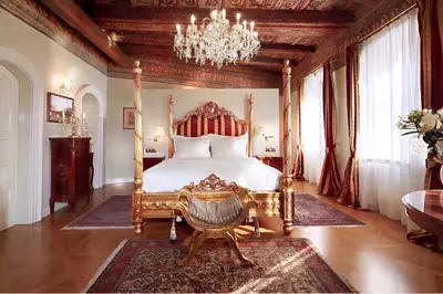 a bedroom with a bed and a chandelier at Alchymist Prague Castle Suites Hotel in Prague
