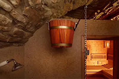a wooden bucket hanging from the wall of a bathroom at Alchymist Prague Castle Suites Hotel in Prague