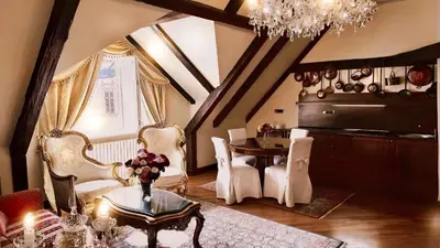 a living room with a table and chairs and a chandelier at Alchymist Prague Castle Suites Hotel in Prague