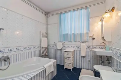 a white bathroom with a tub and a sink at White House in Prague
