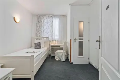 a white room with a bed and a desk at White House in Prague