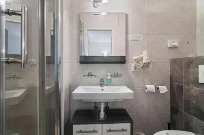 a bathroom with a sink and a mirror and a shower at White House in Prague