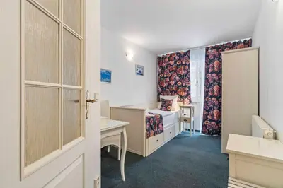a room with a bed and a desk and a window at White House in Prague