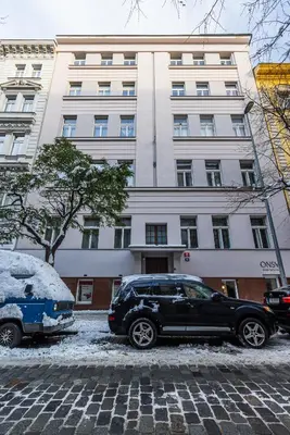 two cars parked in front of a building at Nice big apartment 2bds - Belgicka in Prague