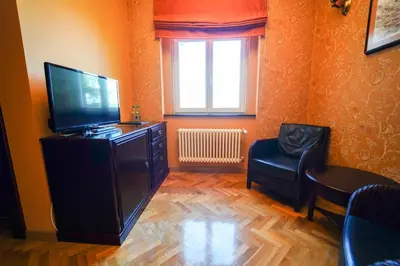 a living room with a flat screen tv and a chair at Rezidence Liběchov in Liběchov