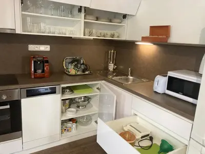 a kitchen with white cabinets and a sink at Apartments near the pond in Prague