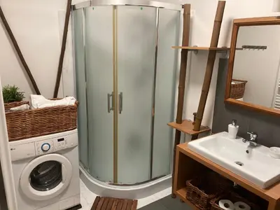a bathroom with a shower and a washing machine at Apartments near the pond in Prague