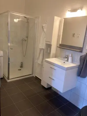 a bathroom with a white sink and a shower at Apartments near the pond in Prague
