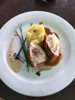 a plate of food with meat and potatoes on a table at Apartments near the pond in Prague