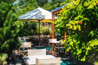 a patio with tables and chairs and an umbrella at Park Holiday Congress & Wellness Hotel in Prague