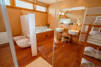 a bathroom with two sinks and a toilet and a mirror at Park Holiday Congress & Wellness Hotel in Prague
