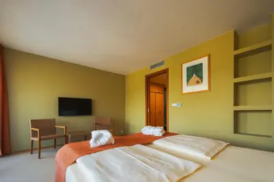 a bedroom with two white towels on a bed at Park Holiday Congress & Wellness Hotel in Prague
