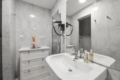 a white bathroom with a sink and a mirror at Romantic Apartment Prague near Charles Bridge in Prague