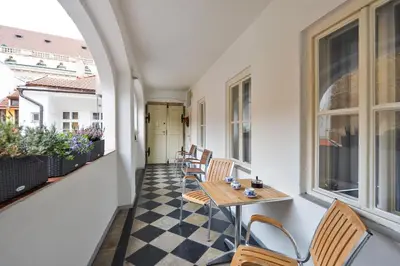 a balcony with chairs and a table on a building at Romantic Apartment Prague near Charles Bridge in Prague