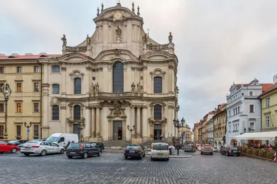 a large building with cars parked in front of it at Romantic Apartment Prague near Charles Bridge in Prague