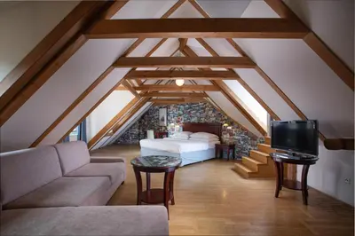 a attic room with a bed and a couch at Charles Bridge Heritage Suites by SALVATOR HOTELS in Prague
