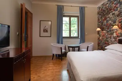 a hotel room with a bed and a television at Charles Bridge Heritage Suites by SALVATOR HOTELS in Prague