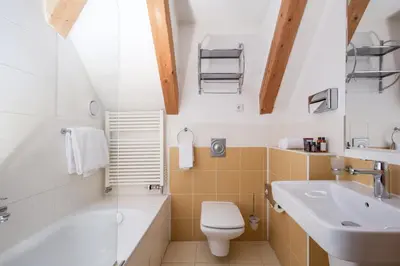 a bathroom with a sink and a toilet and a tub at Charles Bridge Heritage Suites by SALVATOR HOTELS in Prague