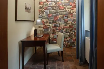 a desk with a chair in a room with a wall at Charles Bridge Heritage Suites by SALVATOR HOTELS in Prague