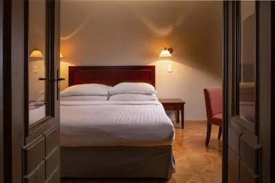 a bedroom with a bed with white sheets and pillows at Charles Bridge Heritage Suites by SALVATOR HOTELS in Prague