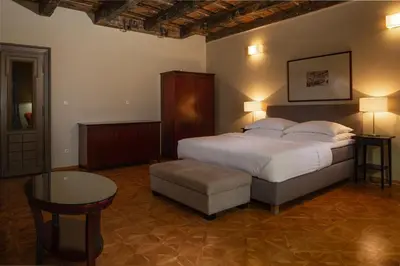a bedroom with a large bed and a table at Charles Bridge Heritage Suites by SALVATOR HOTELS in Prague