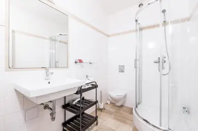 a white bathroom with a sink and a shower at Alt pension in Prague
