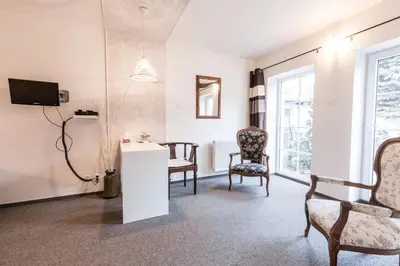 a living room with two chairs and a tv at Alt pension in Prague