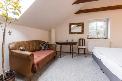 a bedroom with a couch and a table and a bed at Alt pension in Prague