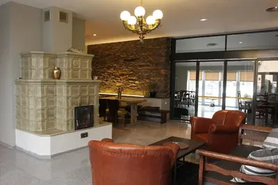 a living room with a fireplace and a table and chairs at Alt pension in Prague