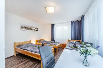 a room with two beds and a table and chairs at Pension Milada in Klecany