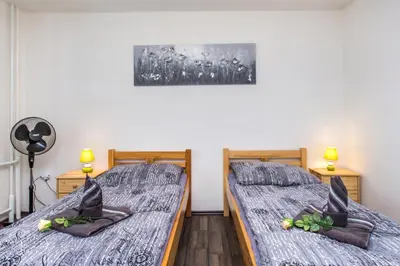 two twin beds in a room with two lamps at Pension Milada in Klecany