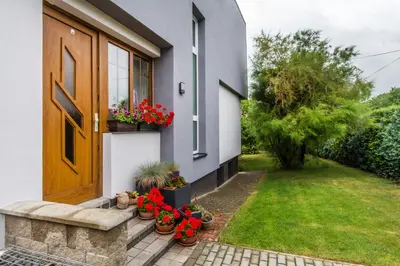 a door to a house with potted plants and a yard at Pension Milada in Klecany