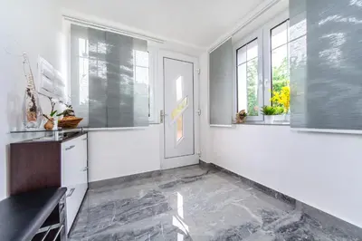 a kitchen with white walls and windows and a door at Pension Milada in Klecany