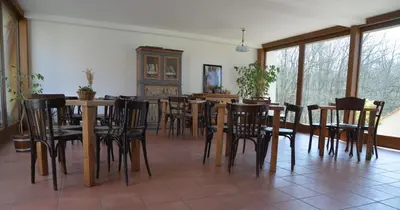 a dining room with wooden tables and chairs at Statek Krkavčí Hora in Nižbor
